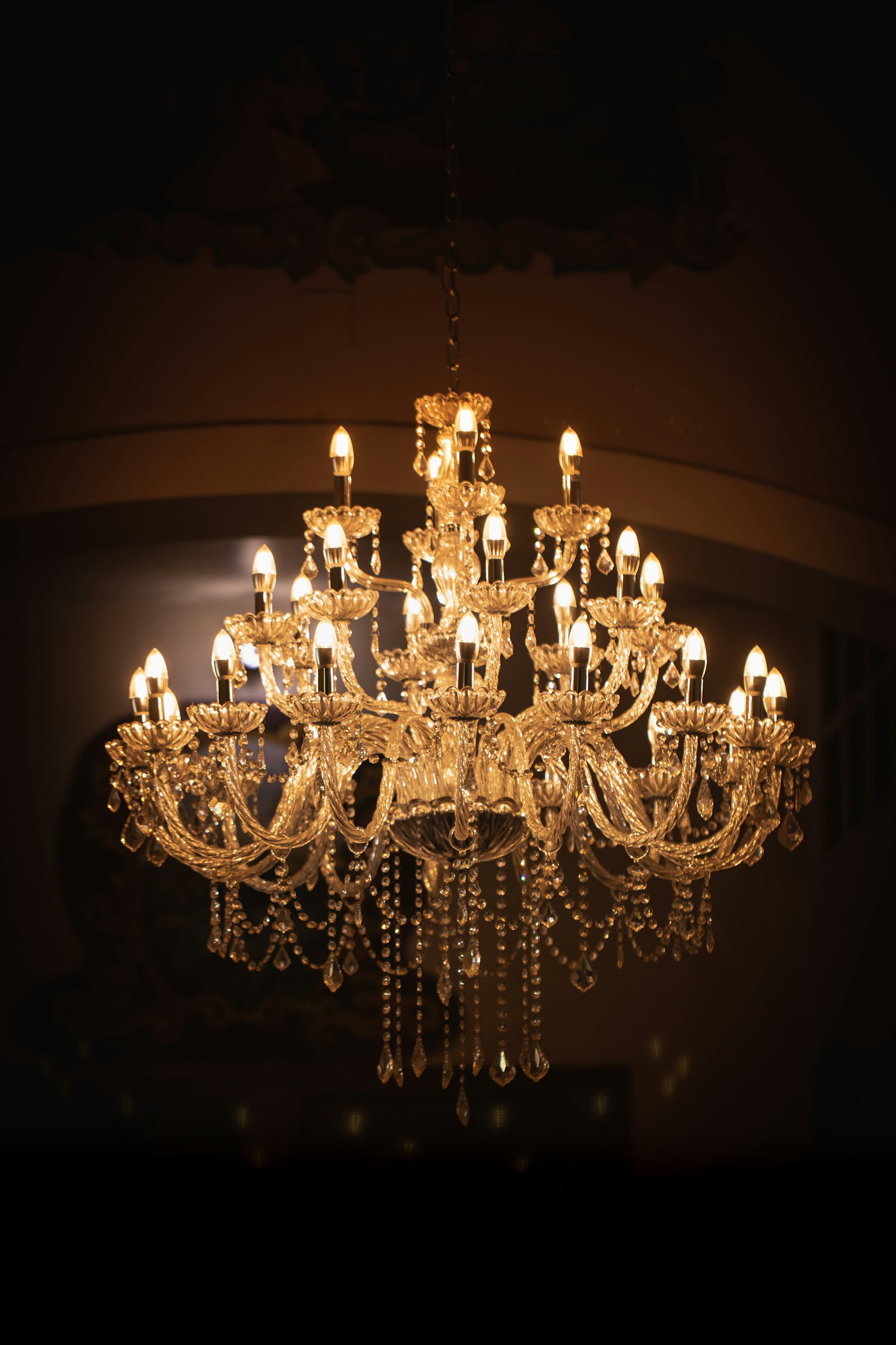 Brass chandelier lit in a room Brass chandelier lit in a room