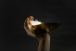 Hand holding a polished brass bowl
