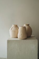 Three clay vessels on a plinth