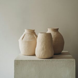 Three clay vessels on a plinth