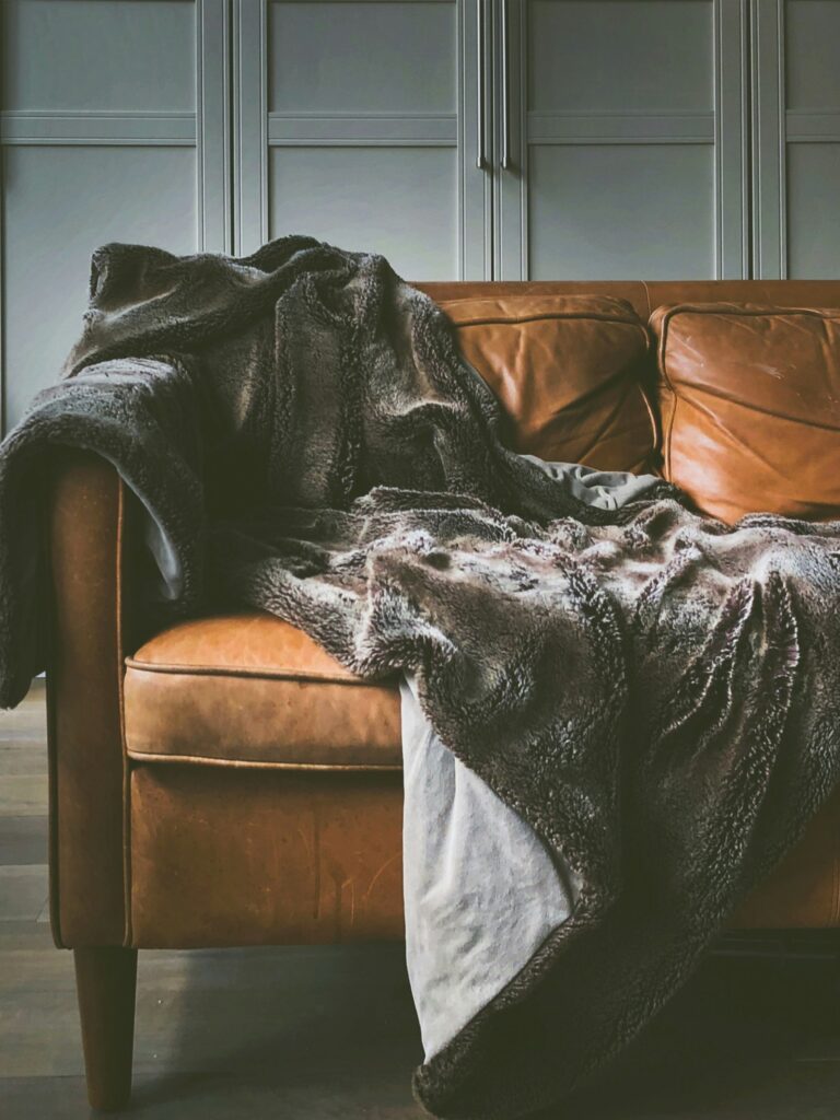 Brown leather sofa with a throw