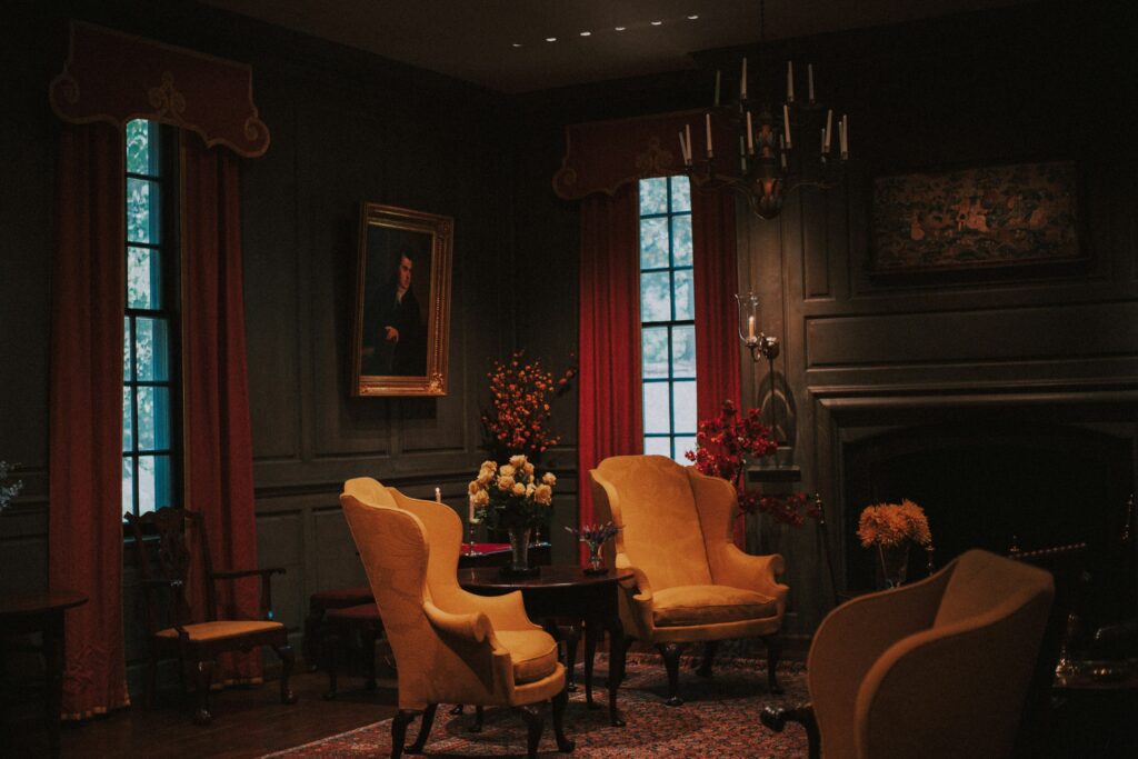 Elegant dark room with armchairs, a chandelier and a fireplace