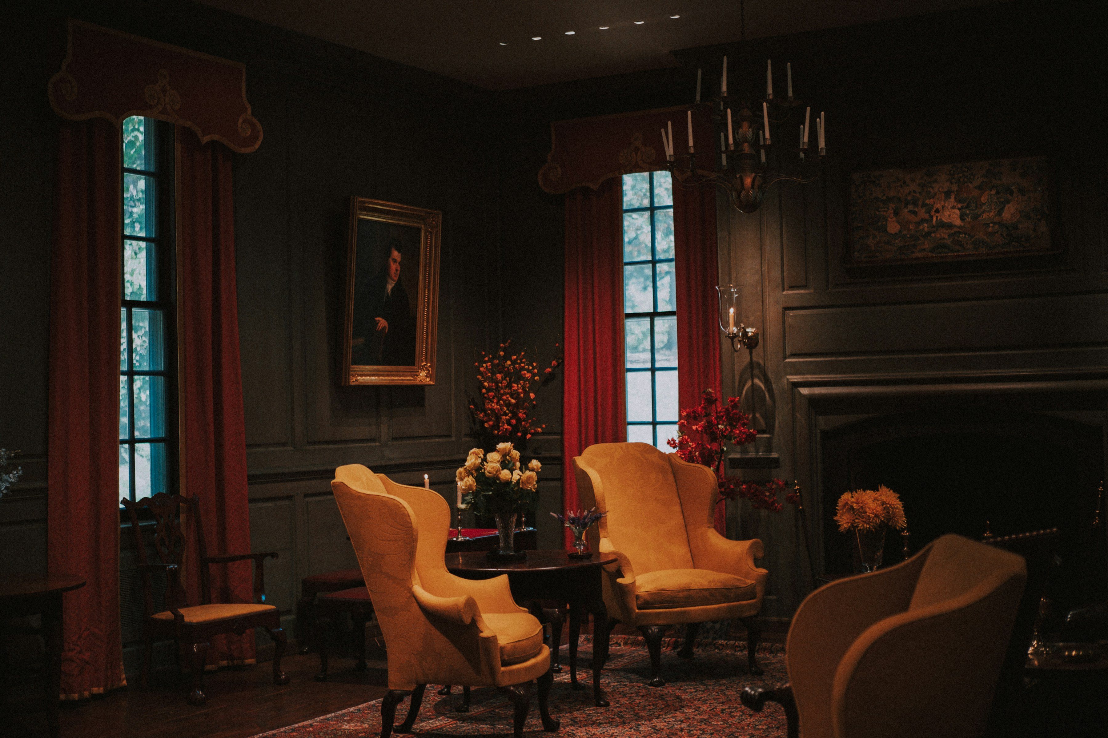 Elegant dark room with armchairs, a chandelier and a fireplace